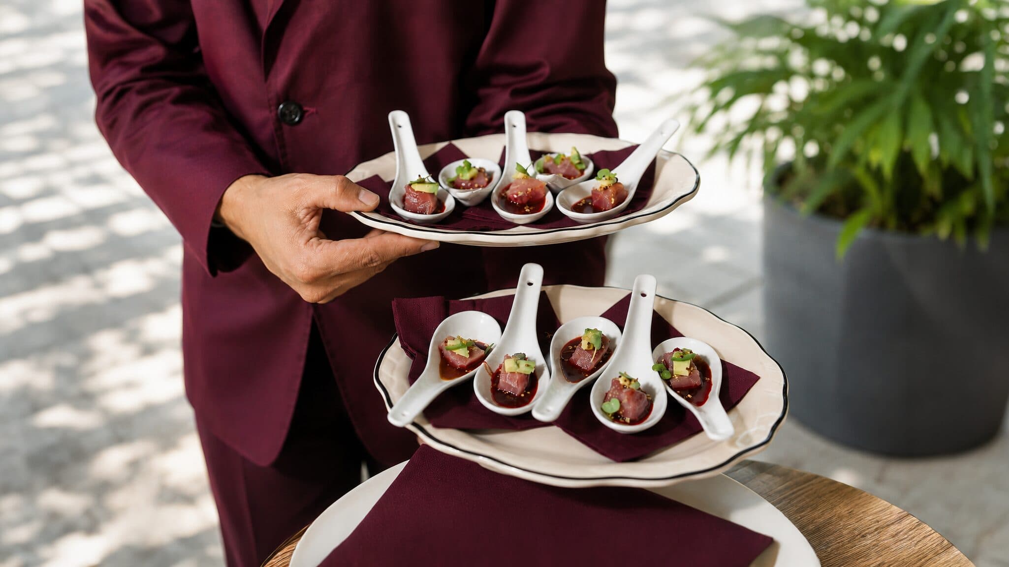 A NOR Table plated dish being finished by hand mid-service.